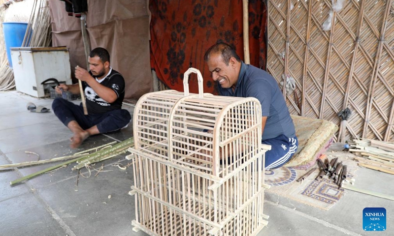 Craftsmen make a bird cage with date palm leaves in Baghdad, Iraq, Jan. 21, 2024. As an important part of the lives of Iraqis, date palms are used to craft furniture, including chairs, tables, beds and bird cages in Iraq. (Xinhua/Khalil Dawood)