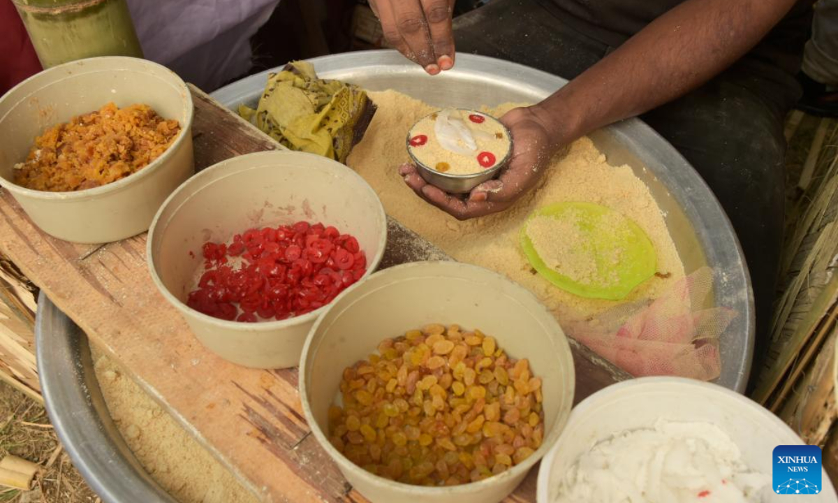 A vendor makes a type of Pitha for sale during a festival in Dhaka, Bangladesh, Jan 31, 2024. Photo:Xinhua