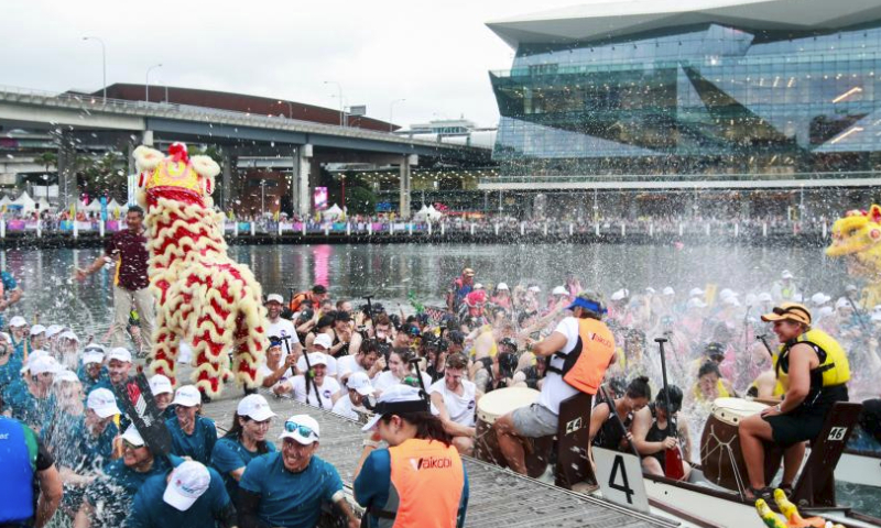 Participants interact with lion dance performers during a welcome ceremony of the dragon boat races at Darling Harbour in Sydney, Australia, Feb. 16, 2024. As part of the celebrations to mark the Chinese Lunar New Year, the dragon boat races kicked off here on Friday and will last till Feb. 18. (Xinhua/Ma Ping)