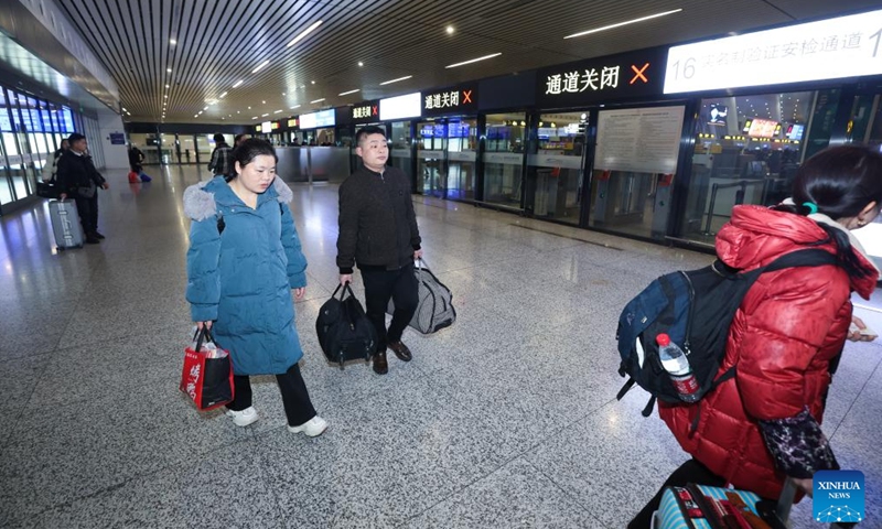 Min Deshui and Long Chunxiang wait to take the train G4835 at Hangzhou East Railway Station in Hangzhou, east China's Zhejiang Province, Feb. 1, 2024.