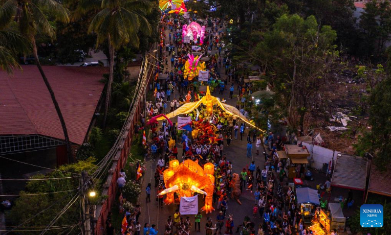 An aerial drone photo taken on Feb. 24, 2024 shows a giant puppet parade on a street in Siem Reap, Cambodia. An annual giant puppet parade was held here on Saturday. (Photo by Sao Khuth/Xinhua)