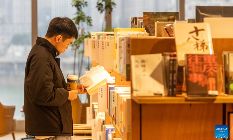 A customer reads a book at Tsutaya Bookstore in Yuzhong District of southwest China's Chongqing Municipality, Jan. 21, 2024. (Xinhua/Chu Jiayin)