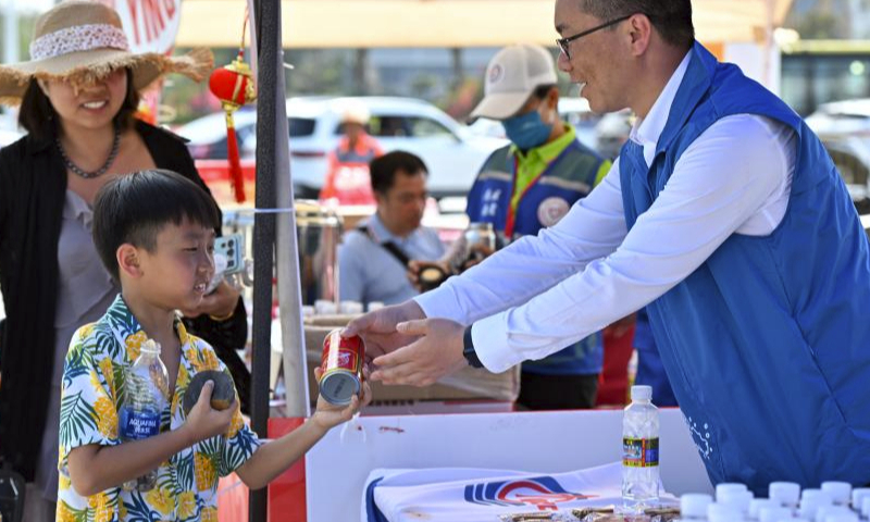 Volunteers offer food and drink to passengers waiting to cross the strait in Haikou, south China's Hainan Province, Feb. 17, 2024. Qiongzhou Strait witnessed a peak of travel rush of returning passengers on Feb. 17, the last day of the Spring Festival holiday.

Various actions were taken by local authorities to ensure passengers to cross the strait in an orderly manner including organizing personnel to maintain the queuing order, providing emergency medicines, drinking water and other supplies to drivers and tourists. (Xinhua/Guo Cheng)