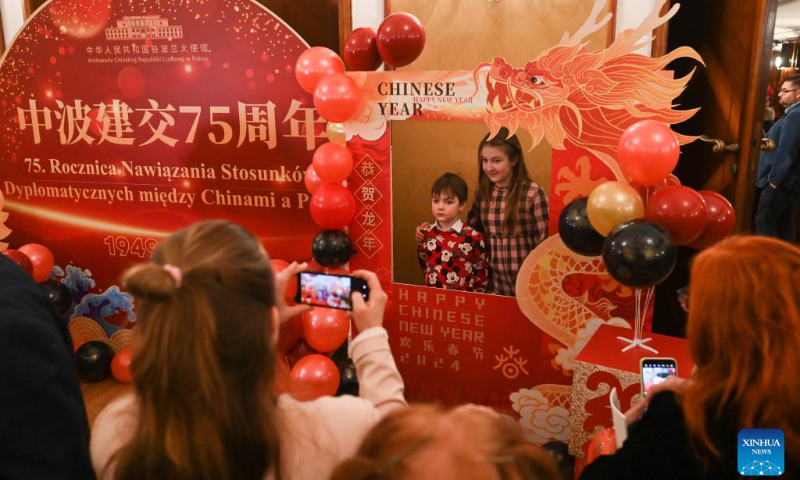 Children pose for photos at a concert hall, where a concert celebrating the Chinese New Year is staged by the China National Traditional Orchestra, in Warsaw, Poland, Feb. 12, 2024. The concert is one stop of the Chinese orchestra's tour in Europe. (Photo: Xinhua)