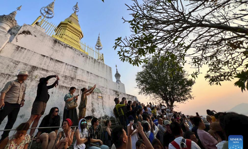 Tourists watch the sunset in Luang Prabang, Laos, Feb. 16, 2024. The China-Laos Railway is witnessing its first Spring Festival travel rush since the railway started cross-border passenger services on April 13, 2023. Laos embraced a boost in tourism thanks to the passenger flow brought by the China-Laos Railway during the Spring Festival holiday. (Photo by Kaikeo Saiyasane/Xinhua)