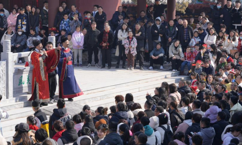 People watch a folk performance at a scenic spot in Kaifeng City, central China's Henan Province, Feb. 12, 2024. During the Spring Festival holiday, various cultural tourism events across central China's Henan Province have attracted lots of tourists. (Photo by Tan Yuzeng/Xinhua)