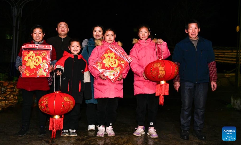 Min Deshui (2nd L) and Long Chunxiang (4th L) pose for a family photo in Ladong Village of Jinping County, southwest China's Guizhou Province, Feb. 1, 2024.