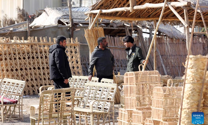 Customers shop for furniture made from date palm leaves in Baghdad, Iraq, Jan. 21, 2024. As an important part of the lives of Iraqis, date palms are used to craft furniture, including chairs, tables, beds and bird cages in Iraq. (Xinhua/Khalil Dawood)