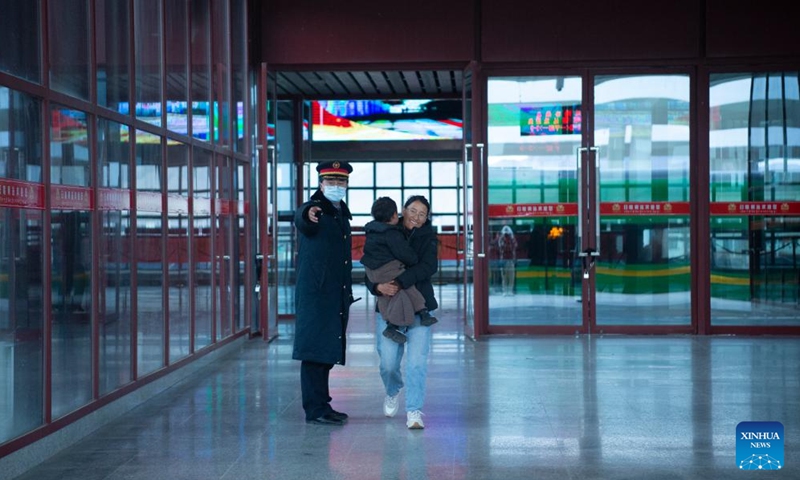 A staff member instructs passengers at Xigaze Station in Xigaze, southwest China's Xizang Autonomous Region, Jan. 27, 2024. China officially ushered in its largest annual population migration on Friday, 15 days ahead of the Spring Festival, or the Lunar New Year, with record-breaking journey numbers expected. (Photo by Tenzin Norbu/Xinhua)