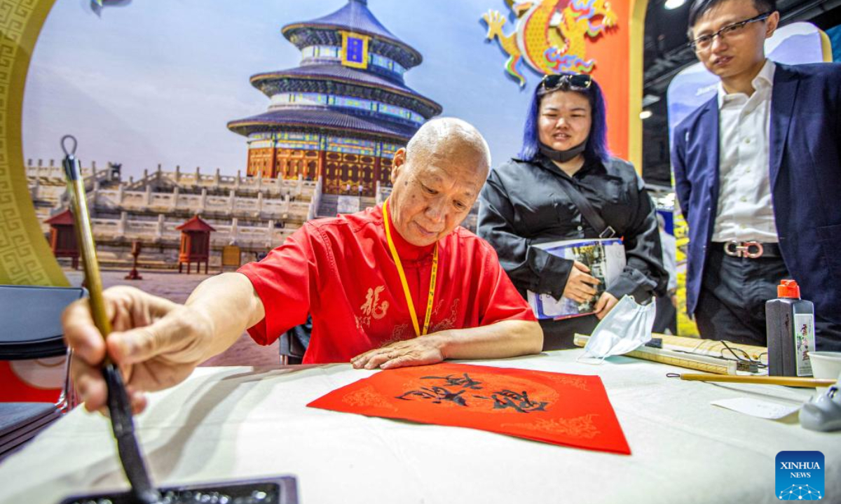 A staff member demonstrates calligraphy skills at a booth of China during the 29th Thailand International Travel Fair in Bangkok, Thailand, Jan 25, 2024. The fair kicked off here on Thursday and will last until Jan 28. Photo:Xinhua