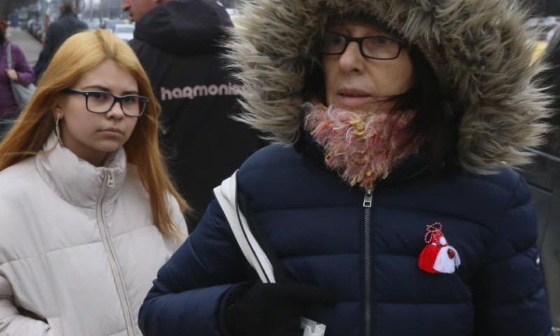 A woman wearing Martenitsa is seen in Sofia, Bulgaria, March 1, 2024. Bulgarian people marked the day named Baba Marta on Friday. On that day and a few days afterwards, Bulgarians exchange and wear the so-called Martenitsa - a small piece of adornment, made of white and red yarn. (Xinhua/Lin Hao)