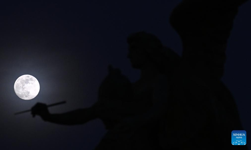 The moon is seen behind a statue in Piazza Venezia in Rome, on Jan. 24, 2024.(Photo: Xinhua)