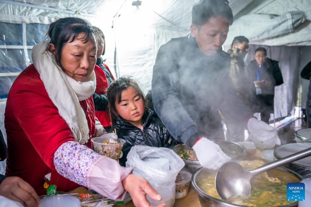 People get their meals at a temporary shelter in Liangshui Village of Tangfang Town, Zhenxiong County, southwest China's Yunnan Province, Jan. 24, 2024. The death toll from a landslide that struck a mountainous village in southwest China's Yunnan Province on Monday had climbed to 34 as of 5 p.m. Wednesday, local authorities said.(Photo: Xinhua)