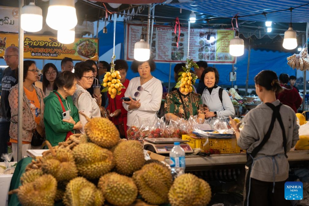 Customers watch as a vendor sells food during Lao Food Festival in Vientiane, capital of Laos on Jan. 23, 2024. The annual Lao Food Festival is held here from January 23 to 27.(Photo: Xinhua)