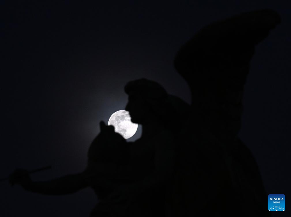 The moon is seen behind a statue in Piazza Venezia in Rome, on Jan. 24, 2024(Photo: Xinhua)