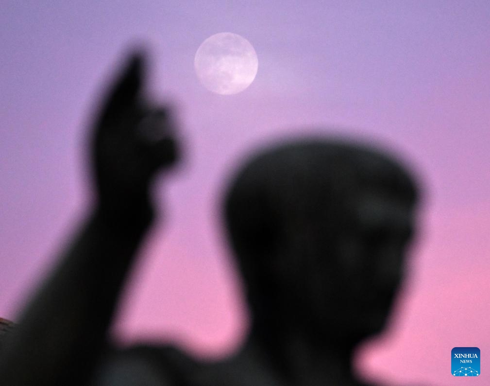 The moon is seen behind the statue of Nerva on Via dei Fori Imperiali in Rome, on Jan. 24, 2024.(Photo: Xinhua)