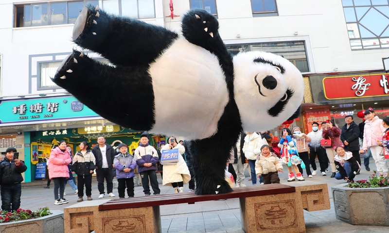 A folk artist dressed up as a cartoon giant panda performs on January 28, 2024 in Suzhou,East China's Jiangsu
Province, as the 