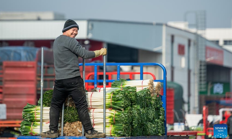 A dealer transfers agricultural products at an agricultural trade center in Xiaogan, central China's Hubei Province, Jan. 27, 2024. The agricultural trade center, which houses nearly 3,000 dealers of fruits, vegetables, aquatic and frozen products, has taken extra measures to ensure its supply for the upcoming Spring Festival holiday. (Xinhua/Wu Zhizun)