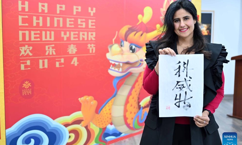 Kuwaiti royal family member Sheikha Anoud displays her calligraphy during a culture event at Kuwait Chinese Cultural Center in Hawalli Governorate, Kuwait, Jan. 25, 2024. A culture event for the upcoming Chinese Spring Festival was held here Thursday, with more than 100 guests gathering to taste traditional food and experience Chinese ink painting, calligraphy, paper-cutting and tea art. (Photo by Asad/Xinhua)