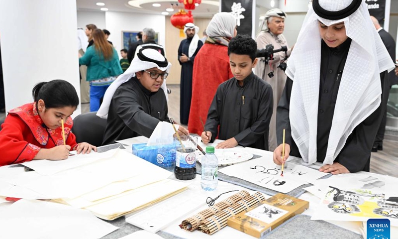Children experience Chinese painting during a culture event at Kuwait Chinese Cultural Center in Hawalli Governorate, Kuwait, Jan. 25, 2024. A culture event for the upcoming Chinese Spring Festival was held here Thursday, with more than 100 guests gathering to taste traditional food and experience Chinese ink painting, calligraphy, paper-cutting and tea art. (Photo by Asad/Xinhua)