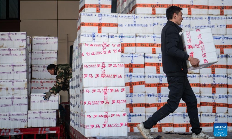 Dealers transfer boxed agricultural products at an agricultural trade center in Xiaogan, central China's Hubei Province, Jan. 27, 2024. The agricultural trade center, which houses nearly 3,000 dealers of fruits, vegetables, aquatic and frozen products, has taken extra measures to ensure its supply for the upcoming Spring Festival holiday. (Xinhua/Wu Zhizun)