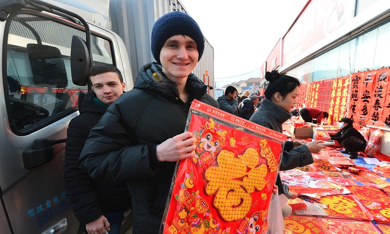 A student (front) from Russia shops for items with the Chinese character Fu, which means good fortune and happiness, in Qingdao, East China's Shandong Province on January 29, 2024. More than 10 international students from Russia, Bangladesh and Sri Lanka shopped at the market to experience the vibe for the Spring Festival holidays. Photo: VCG
