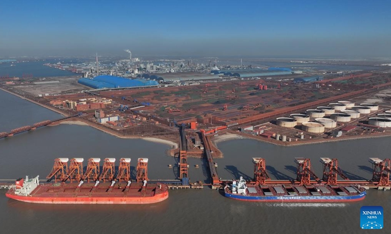 An aerial drone photo taken on Jan. 26, 2024 shows ships unloading cargo at the ore wharf of the Caofeidian port area of Tangshan Port in north China's Hebei Province. The province's cargo throughput reached a record high of 1.36 billion tonnes in 2023. (Xinhua/Yang Shiyao)