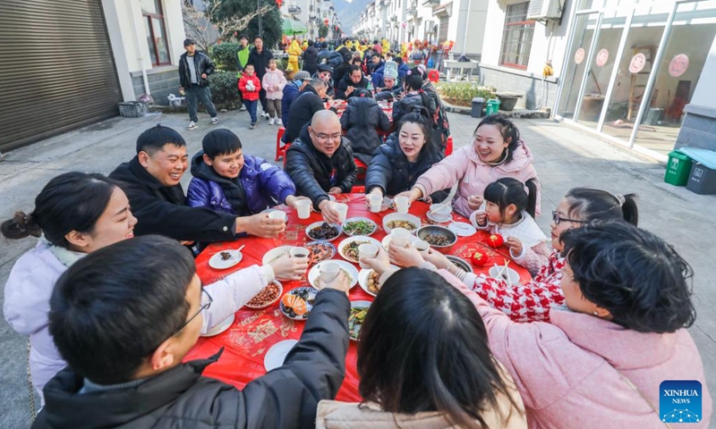 People take part in an open-air banquet during a Chinese New Year culture festival in Lianhua Town of Jiande City, east China's Zhejiang Province, Jan. 28, 2024. A culture festival celebrating the upcoming Chinese New Year is held in Lianhua Town on Sunday. Tourists enjoyed watching traditional performances while having delicacies at a large open-air banquet consisted of 100 tables amid a bustling and festive atmosphere. (Xinhua/Xu Yu)