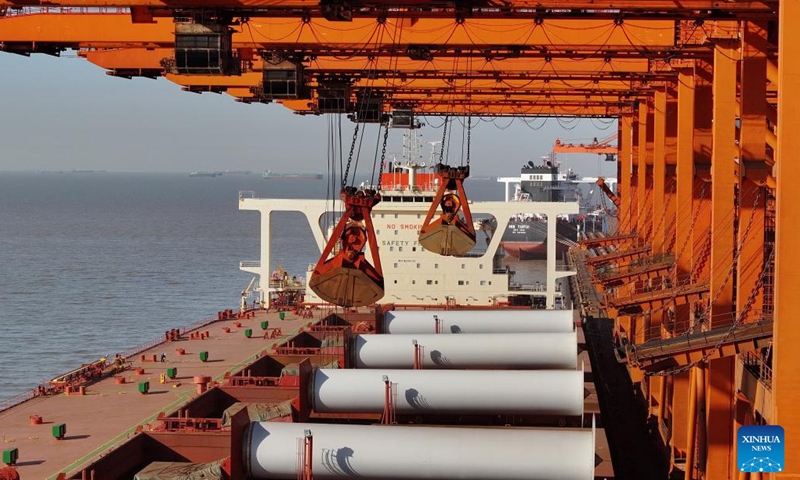 A drone photo taken on Jan. 26, 2024 shows a ship unloading cargo at the ore wharf of the Caofeidian port area of Tangshan Port in north China's Hebei Province. The province's cargo throughput reached a record high of 1.36 billion tonnes in 2023. (Xinhua/Yang Shiyao)