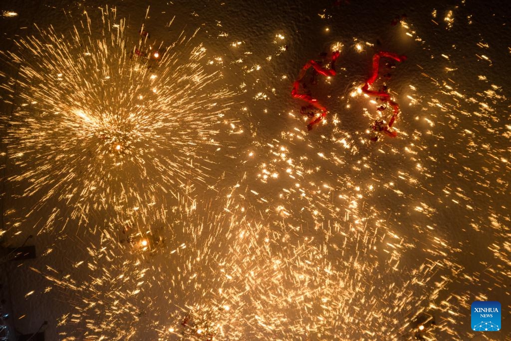 Actors perform a fire dragon dance in a shower of molten iron at the Volga Manor in Harbin, northeast China's Heilongjiang Province on Jan. 29, 2024. As the final stop of a perform tour which started from Tongliang District of Chongqing Municipality to greet the upcoming Spring Festival, actors of the Tongliang Dragon Dance team staged a grand fire dragon dance show for tourists here on Monday.(Photo: Xinhua)