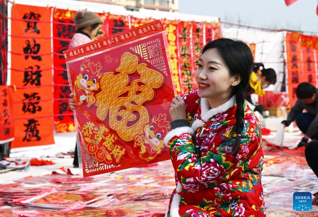 A customer chooses a Chinese character Fu, which means good fortune, at the Poli Market in Qingdao Xihai'an (West Coast) New Area in Qingdao, east China's Shandong Province, Jan. 29, 2024. With a history of more than 300 years, the Poli Market is a local intangible cultural heritage and one of the biggest traditional markets in eastern Shandong Province. (Photo: Xinhua)