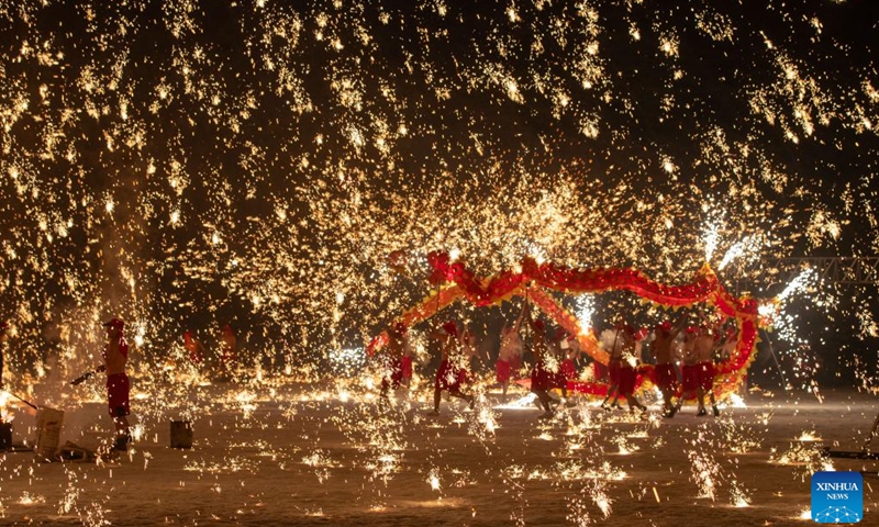 Actors perform a fire dragon dance in a shower of molten iron at the Volga Manor in Harbin, northeast China's Heilongjiang Province on Jan. 29, 2024. As the final stop of a perform tour which started from Tongliang District of Chongqing Municipality to greet the upcoming Spring Festival, actors of the Tongliang Dragon Dance team staged a grand fire dragon dance show for tourists here on Monday.(Photo: Xinhua)