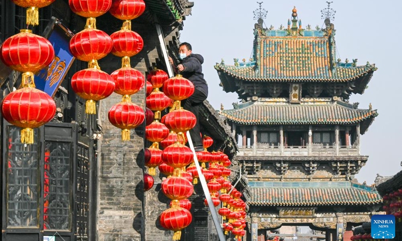 A man hangs red lanterns to greet the Chinese Lunar New Year in the ancient town of Pingyao in north China's Shanxi Province, Jan. 29, 2024. Festive decorations are seen across the country as the Spring Festival approaches.(Photo: Xinhua)