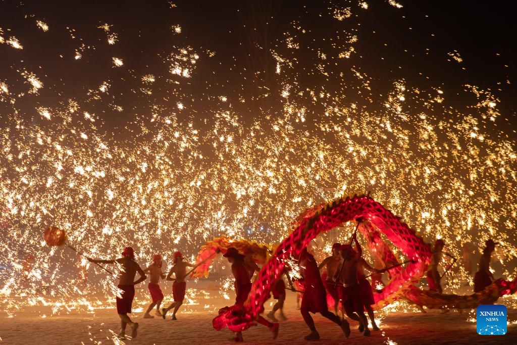 Actors perform a fire dragon dance in a shower of molten iron at the Volga Manor in Harbin, northeast China's Heilongjiang Province on Jan. 29, 2024. As the final stop of a perform tour which started from Tongliang District of Chongqing Municipality to greet the upcoming Spring Festival, actors of the Tongliang Dragon Dance team staged a grand fire dragon dance show for tourists here on Monday.(Photo: Xinhua)