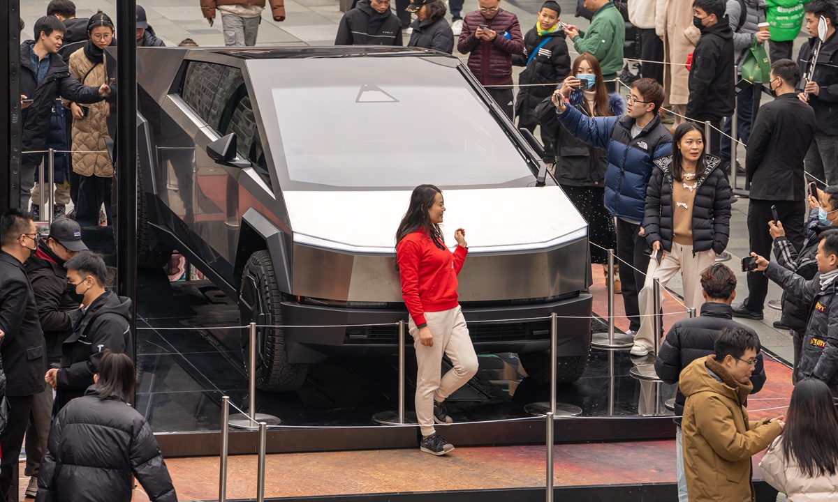 A woman poses for a photo in front of a Cybertruck displayed in a commercial district in Chengdu, Southwest China's Sichuan Province on January 31, 2024. Tesla launched a road show in China of its flagship Cybertruck pickup across eight Chinese cities this week. Photo: VCG