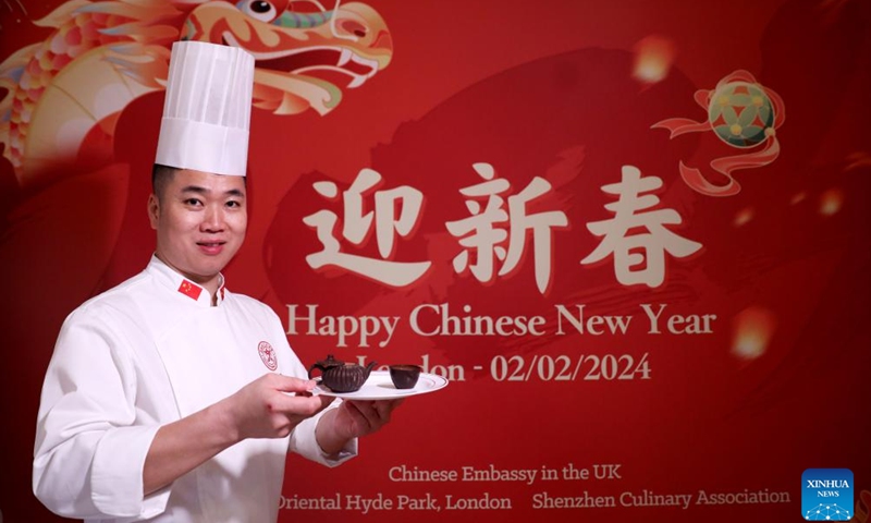 A chef shows teapot- and teacup-shaped chocolate desserts during a Chinese cuisine tasting event held at Mandarin Oriental Hyde Park Hotel in London, Britain, Feb. 2, 2024. During a Chinese cuisine tasting event held here on Friday, four master chefs from Shenzhen Culinary Association introduced the characteristics of Cantonese Cuisine, explained the cooking methods, and invited guests to prepare and taste the traditional Chinese Year's Eve dinner. (Xinhua/Li Ying)