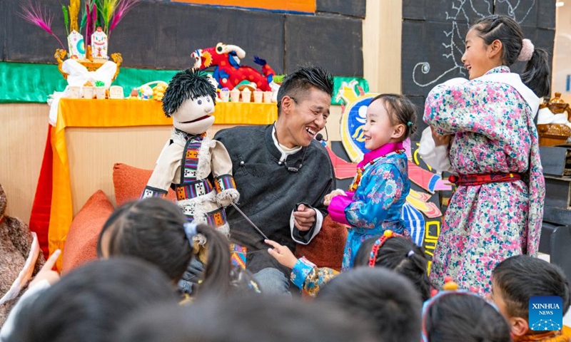 An actor interacts with children during a party at a bookstore in Lhasa, southwest China's Xizang Autonomous Region, Feb. 3, 2024.