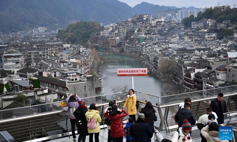 Tourists visit a sightseeing trail outside a station of Fenghuang maglev sightseeing express line at Fenghuang ancient town in Xiangxi Tujia and Miao Autonomous Prefecture, central China's Hunan Province, Feb. 1, 2024. 