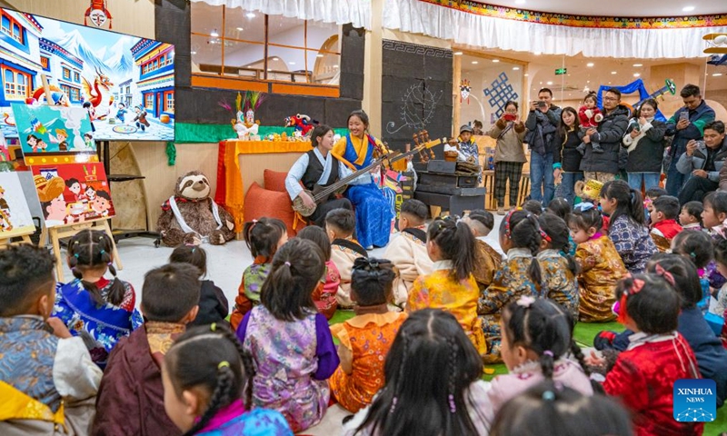 Actors play a local six-string instrument during a party at a bookstore in Lhasa, southwest China's Xizang Autonomous Region, Feb. 3, 2024.