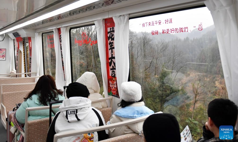 Tourists enjoy the scenery aboard Fenghuang maglev sightseeing express line at Fenghuang ancient town in Xiangxi Tujia and Miao Autonomous Prefecture, central China's Hunan Province, Feb. 2, 2024.