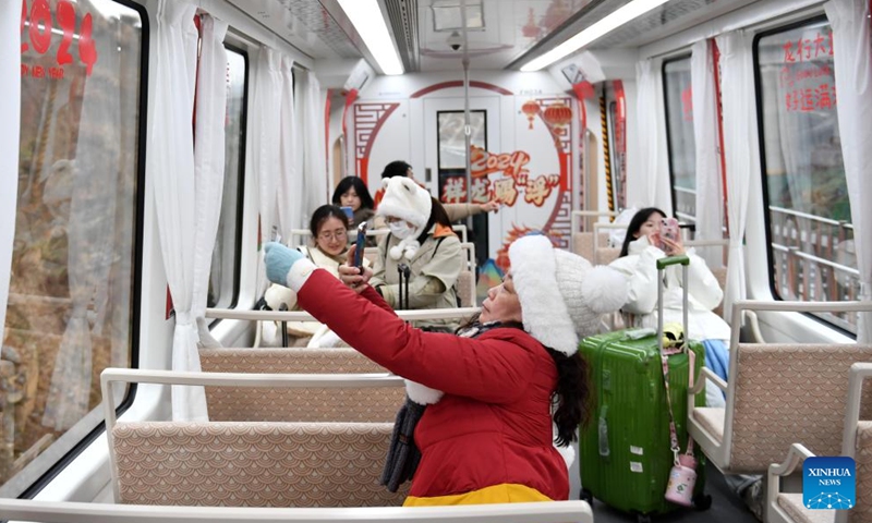 Tourists enjoy the scenery aboard Fenghuang maglev sightseeing express line at Fenghuang ancient town in Xiangxi Tujia and Miao Autonomous Prefecture, central China's Hunan Province, Feb. 2, 2024.