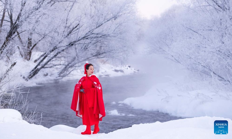 A tourist enjoys the rime scenery along the Kurbin River near Pingtai Village in Xunke County of Heihe, northeast China's Heilongjiang Province, Feb. 2, 2024.