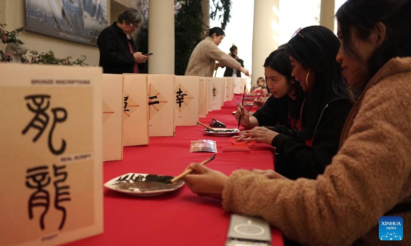 Visitors try their hands on Chinese calligraphy at a Chinese New Year festival at the Huntington Library, Art Museum and Botanical Gardens in Southern California, the United States, Feb. 10, 2024. A series of Chinese Lunar New Year celebrations was held Saturday in Southern California, which is home to most Chinese Americans in the United States. Many people told Xinhua they expected more cultural exchanges between the two countries. (Photo by Zeng Hui/Xinhua)