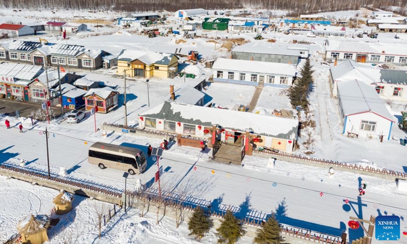 An aerial drone photo taken on Feb. 2, 2024 shows a bus running on a road at Pingtai Village in Xunke County of Heihe, northeast China's Heilongjiang Province.