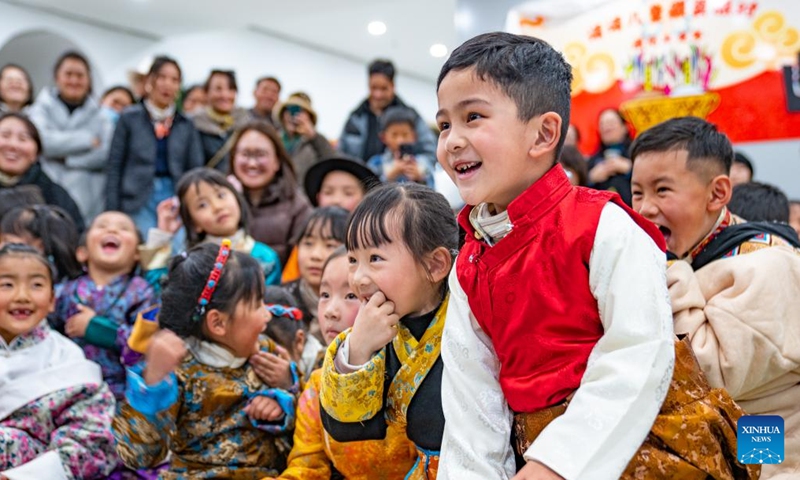 Children watch a puppet show during a party at a bookstore in Lhasa, southwest China's Xizang Autonomous Region, Feb. 3, 2024.