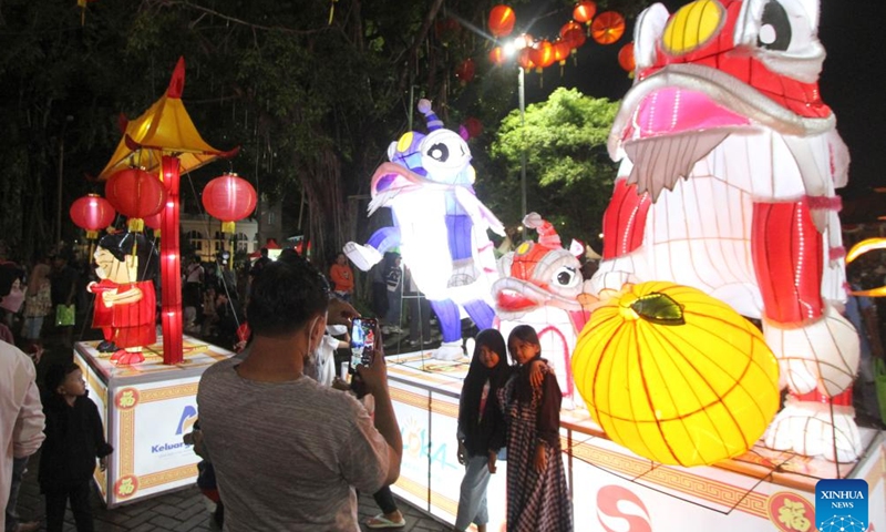 People take pictures as they enjoy light decorations during Chinese Lunar New Year celebration at Surakarta, Central Java, Indonesia, on Feb. 10, 2024. (Photo by Bram Selo/Xinhua)