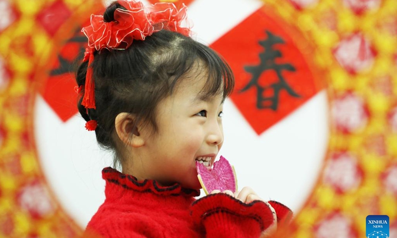 A child bites a radish slice, which is called Yaochun, a ritual expressing the wish for everything to go smoothly on the day of Lichun, meaning the beginning of spring, the first solar term in the traditional Chinese lunar calendar, in Tangshan, north China's Hebei Province, Feb. 4, 2024. (Photo by Zhu Dayong/Xinhua)