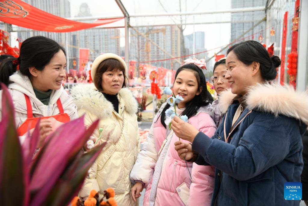 People buy a flower-shaped knit decoration at a flower fair at a park in Chengdu, southwest China's Sichuan Province, Feb. 5, 2024. Flower-themed fairs are being held in Chengdu to celebrate the upcoming Chinese New Year.(Photo: Xinhua)