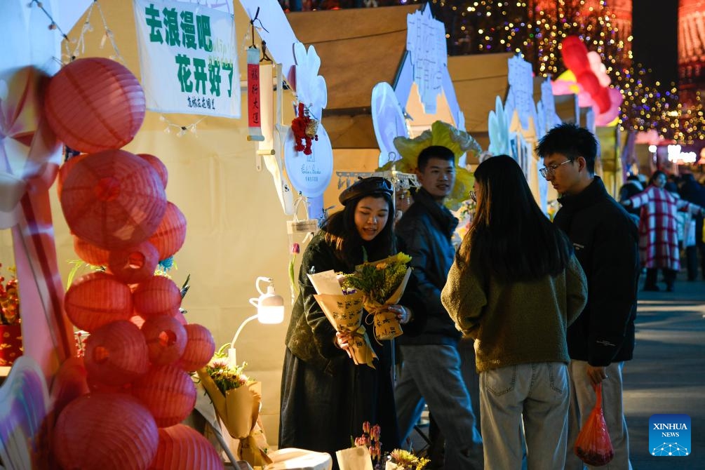 A dealer introduces flowers to customers at a flower fair in a street in Chengdu, southwest China's Sichuan Province, Feb. 4, 2024. Flower-themed fairs are being held in Chengdu to celebrate the upcoming Chinese New Year.(Photo: Xinhua)