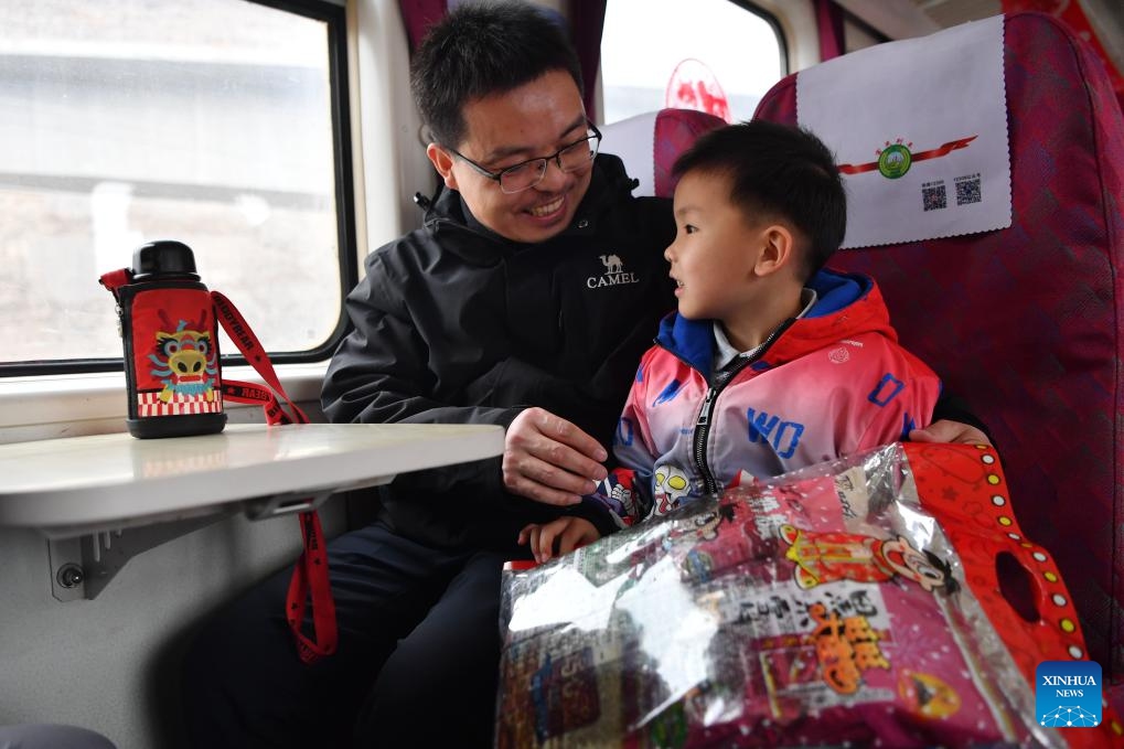 This photo taken on Feb. 4, 2024 shows passengers on their way home after shopping aboard the train No. 7503 in northwest China's Gansu Province. The pair of slow trains No. 7503 and No. 7504 run between Tianshui and Longxi in Gansu. Local residents are now taking them to travel between their towns and the urban areas to shop for goods in preparation of the upcoming Chinese Lunar New Year, or the Spring Festival.(Photo: Xinhua)